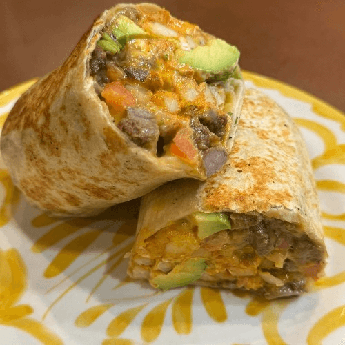 California burrito sliced in half with asada, avocado and cheese
