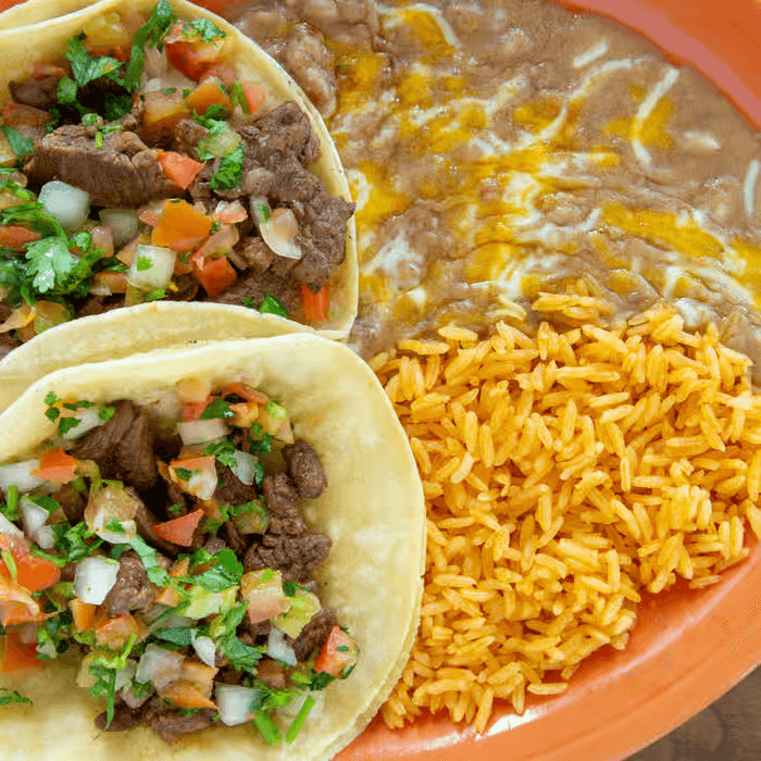 Carne asada tacos with rice and refried beans